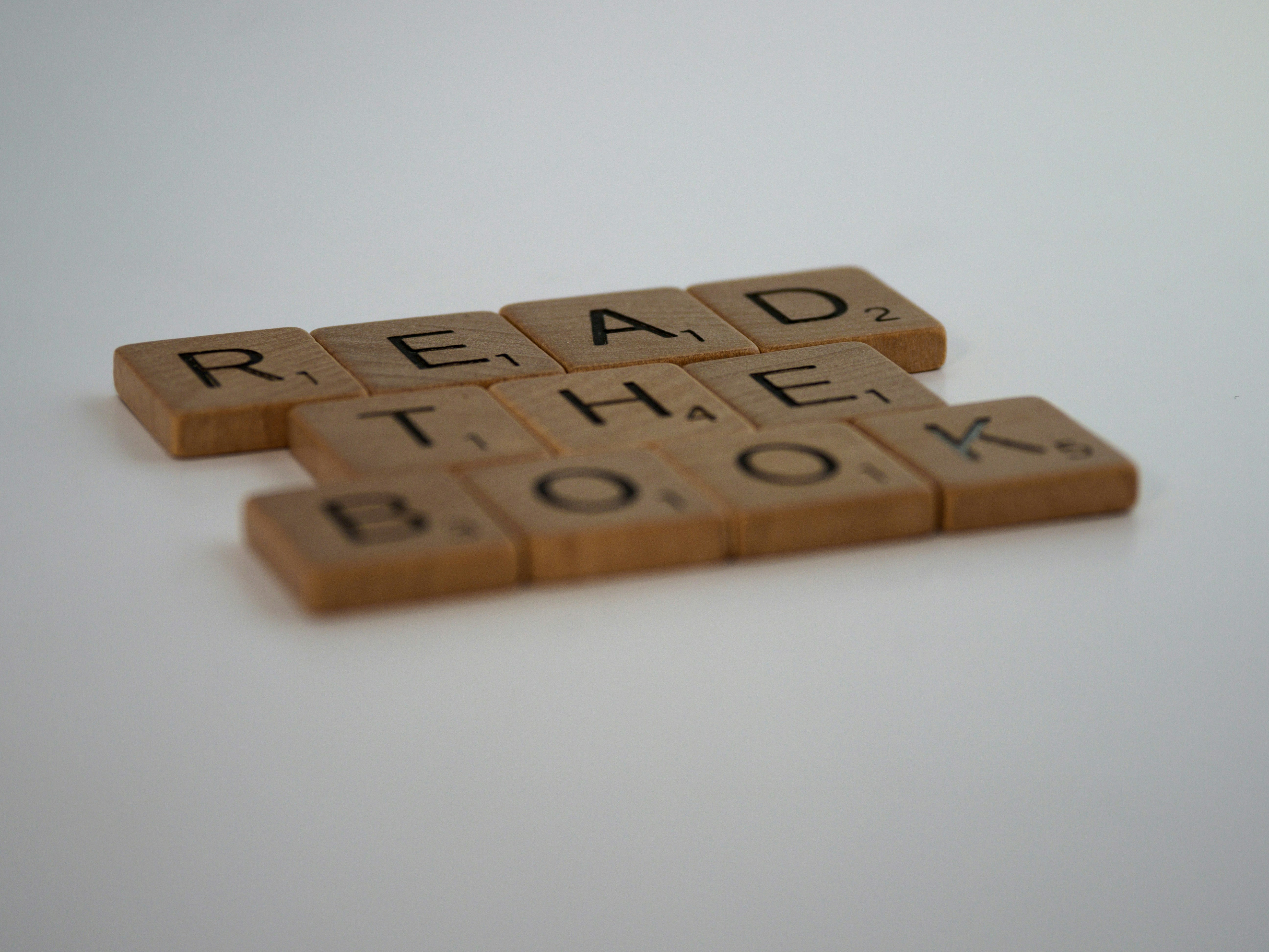 scrabble, scrabble pieces, lettering, letters, white background, wood, scrabble tiles, wood, words, read the book, reading, books, literacy, <br><br>